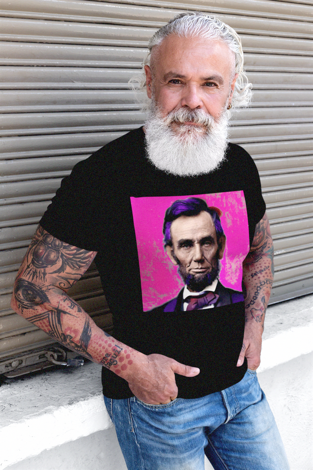 Muscular older man with tattoos and lumberjack beard wearing a basic black t-shirt with a stylized photo of Abraham Lincoln: American Punk From his Second Inaugural Address, delivered near the end of the Civil War, Lincoln’s words capture the nation’s moral high point amid its deepest wound. Great gift for American radicals and history buffs. Bella+Canvas 3001 Basic T-Shirt #EUTC

