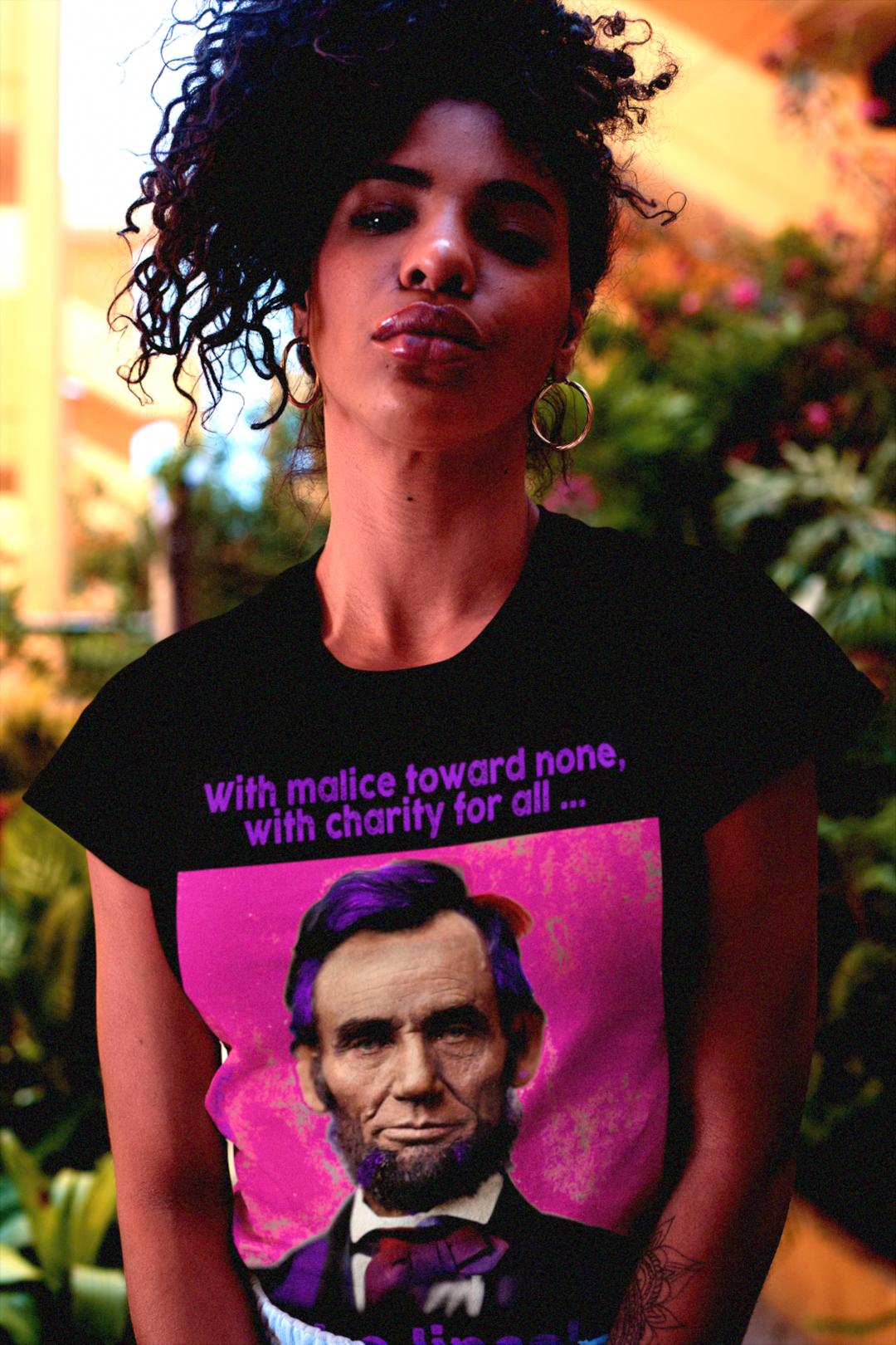 Hip Black woman with beautiful hair wearing Relaxed Fit Women’s Tee with American Punk Abraham Lincoln — “With malice toward none, with charity for all.” From his Second Inaugural Address. Great gift for American radicals. 