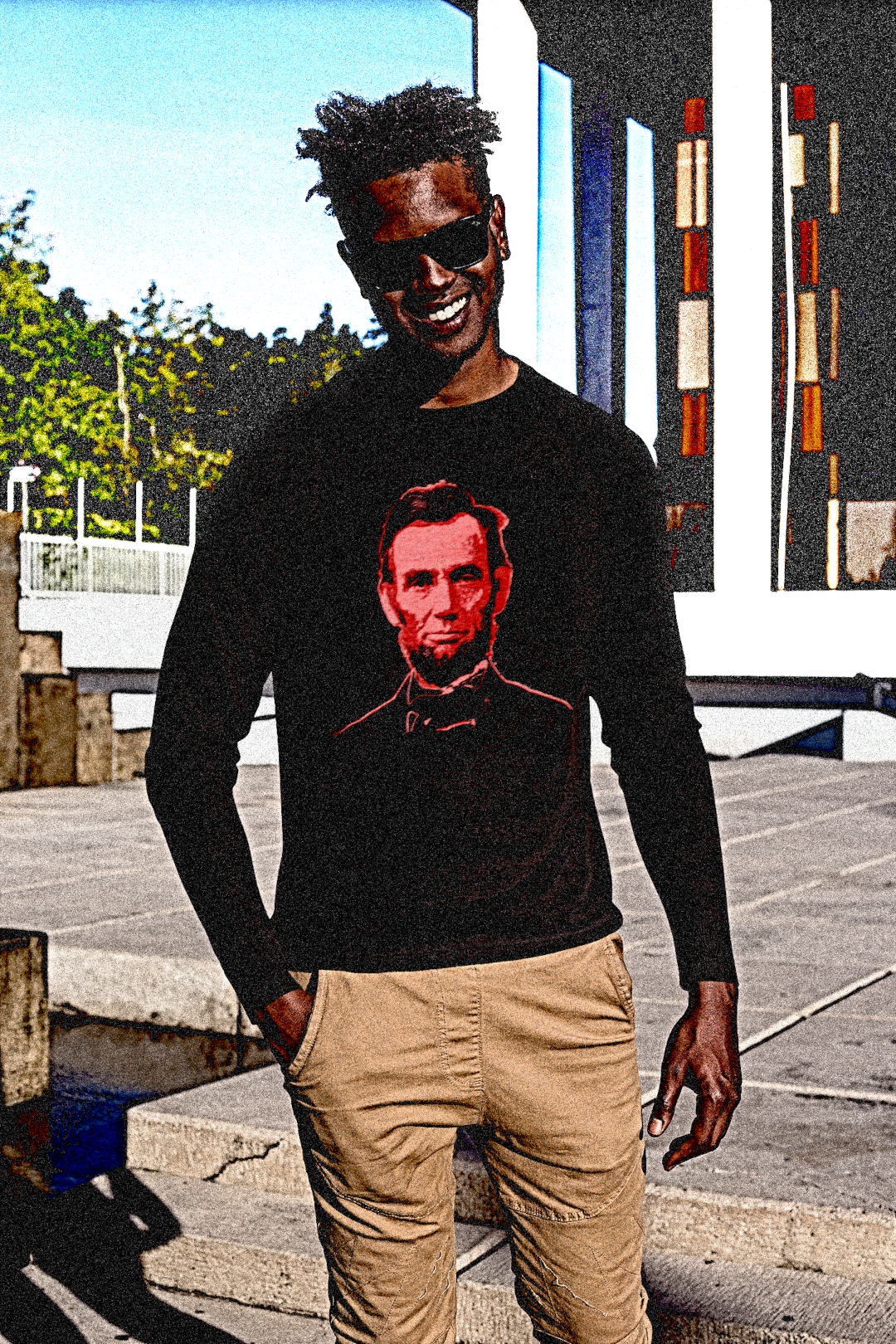 Black dude wearing Wayfarers with short dreadlocks wearing a Long Sleeve Jersey depicting Abraham Lincoln: Blood of the Union portrait. Abraham Lincoln wasn’t a saint dropped from the heavens—he was a messy, pragmatic politician shaped by the rough-and-tumble Free Soil movement and the hard edges of frontier republicanism.  Perfect gift for the political junky in your life or any pragmatic radical. #EUTC