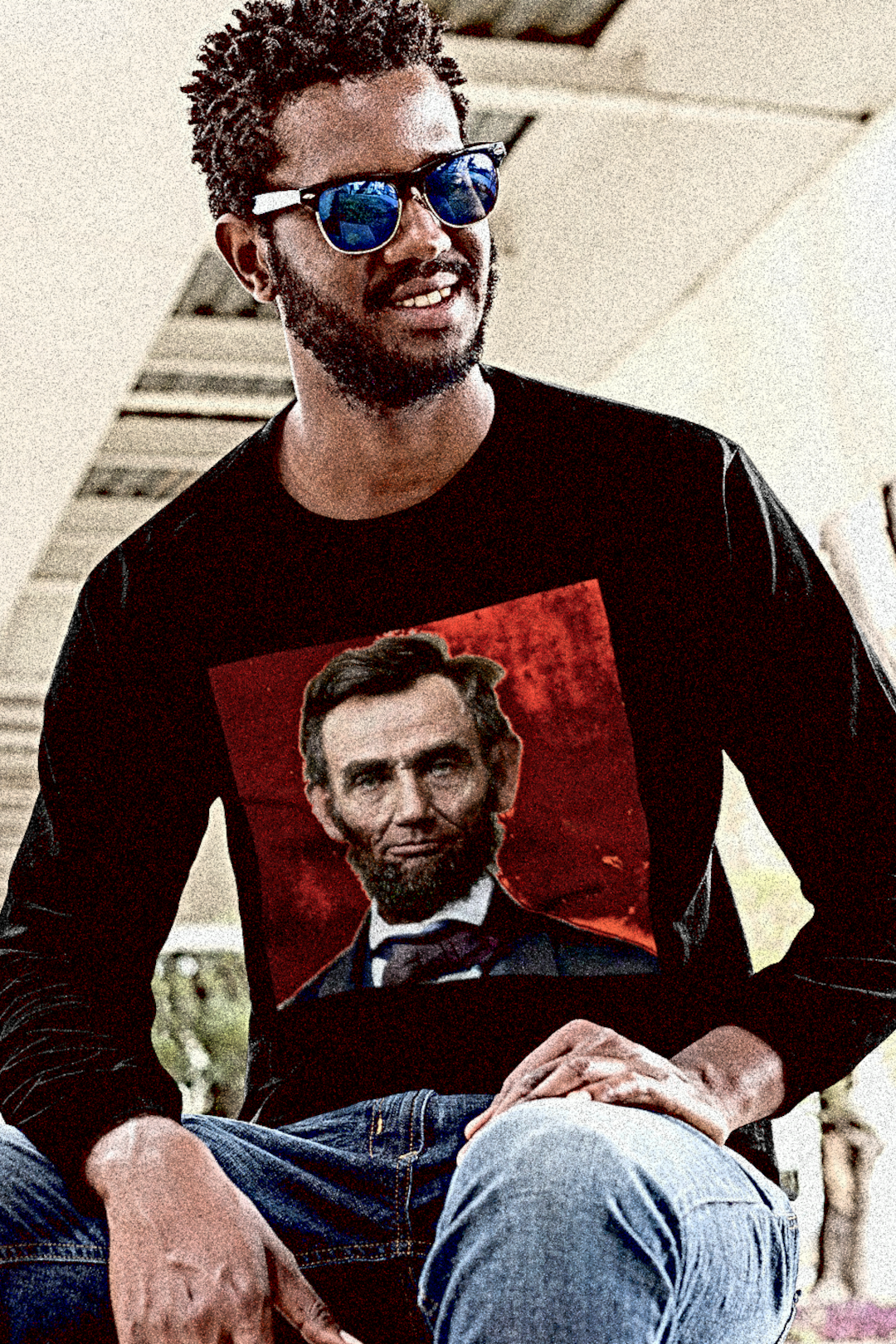 Black dude wearing shades with short dread locks wearing  a Long Sleeve Jersey depicting a colorized Abraham Lincoln | The Country Burns. Abraham Lincoln wasn’t a saint dropped from the heavens—he was a messy, pragmatic politician shaped by the rough-and-tumble Free Soil movement and the hard edges of frontier republicanism. The perfect gift for the history major or American radical in your life. Bella+Canvas 3501 Long Sleeve Jersey #EUTC