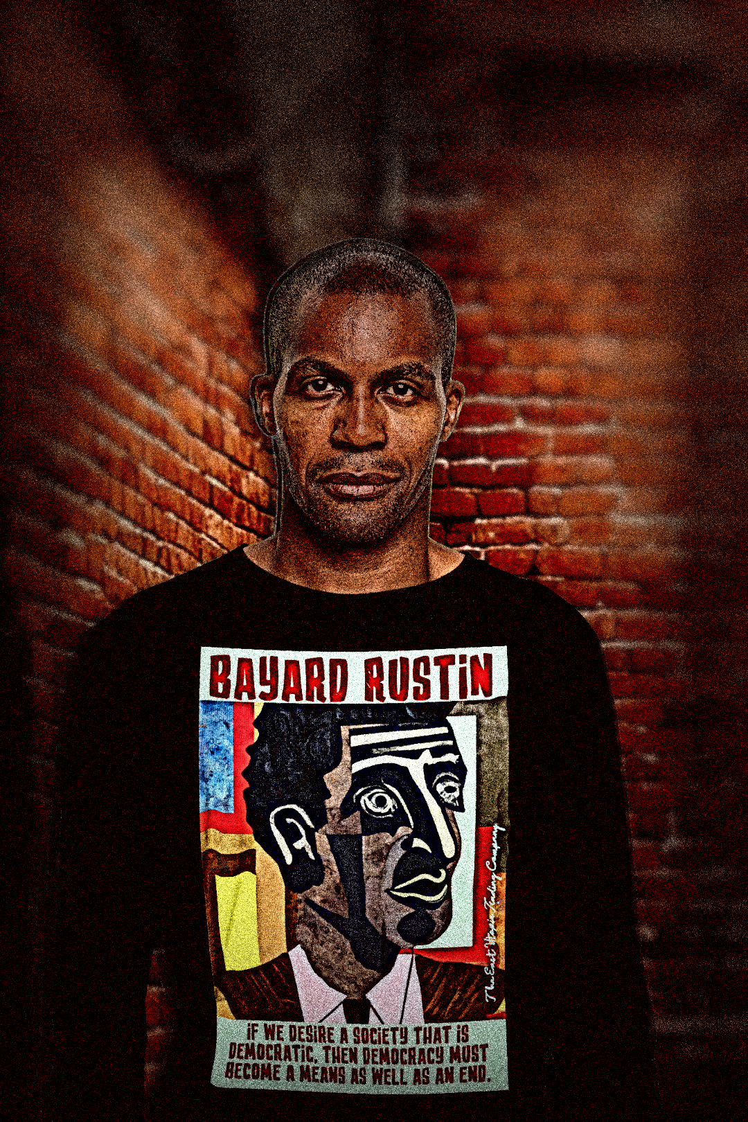 Middle-aged Black man in a brick alley wearing Black Long Sleeve Jersey of Bayard Rustin quote: “If we desire a society that is democratic, then democracy must become a means as well as an end.”

Bayard Rustin was the movement’s hidden architect—the strategist behind the March on Washington, the quiet genius who made nonviolence not just a philosophy but a logistics plan. 

Perfect gift for the civil rights activist in your life. Cotton Bella+Canvas 3501 #EUTC 
