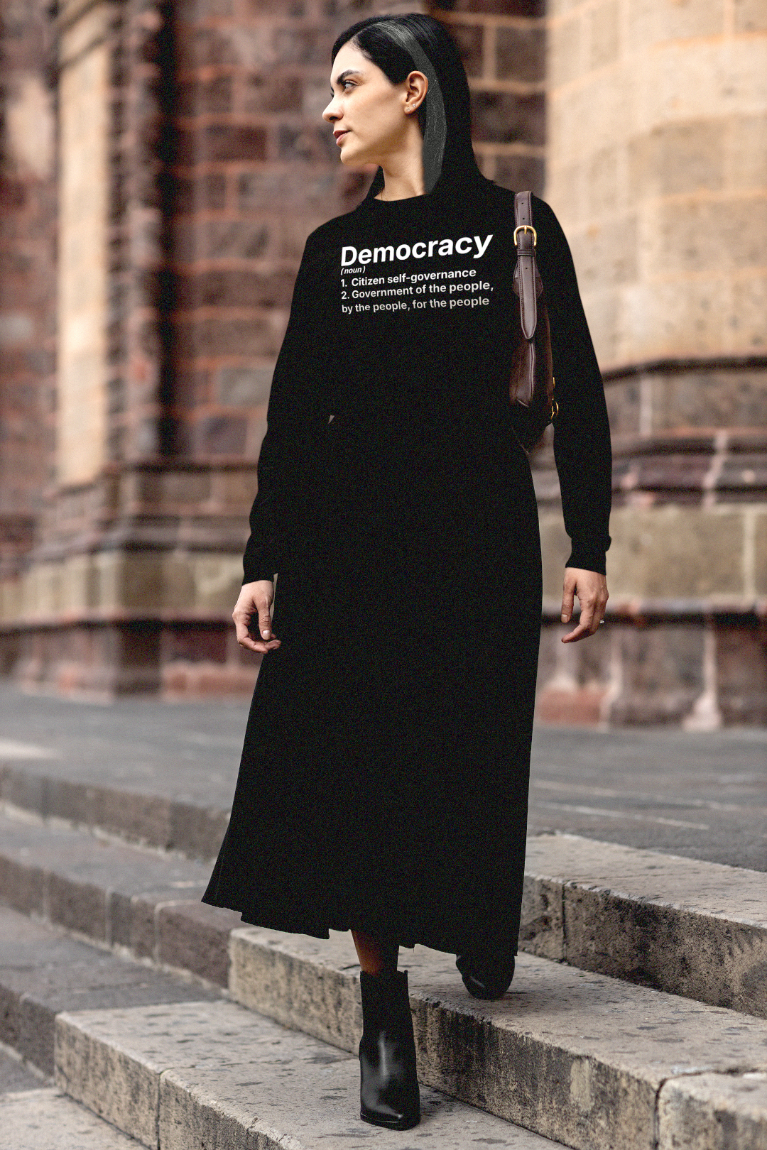 Gothesque law student woman wearing a black long sleeve jersey with 'Democracy' text standing on stone steps. DEMOCRACY
(noun)
1. Citizen self-governance
2. Government of the people, by the people, for the people