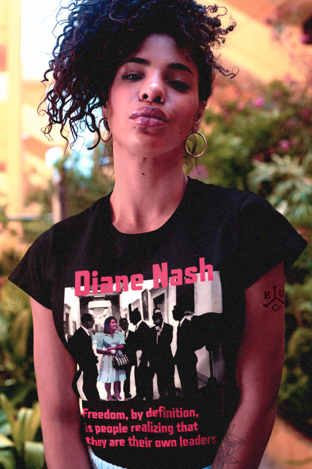 Strong Black woman with kinky hair piled high wearing a Black Relaxed Fit Women's T-Shirt:  Diane Nash was the strategist the movement needed but history almost forgot. As a student leader in SNCC, she organized sit-ins, freedom rides, and voter registration drives with a clarity and toughness that left older male leaders scrambling to keep up. Perfect gift of feminist civil rights activists. Cotton Bella+Canvas 6400 #EUTC