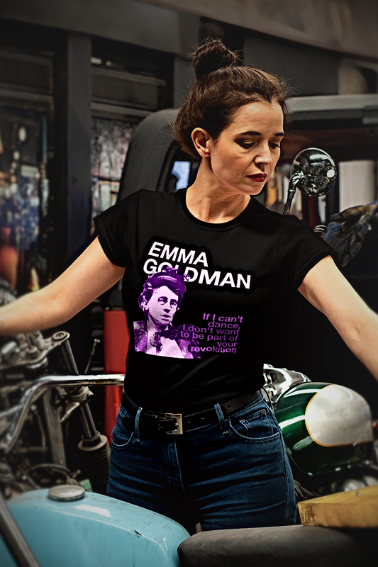 Woman wearing a t-shirt with 'Emma Goldman: If I can't dance", standing in a motorcycle shop.