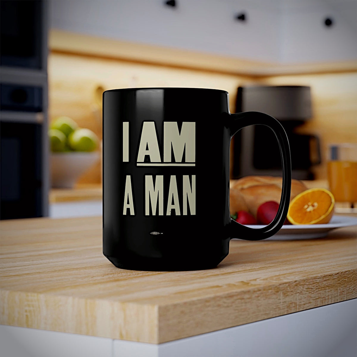 A black ceramic mug with the phrase 'I AM A MAN' printed in bold cream-colored block letters on the front on a butcher block kitchen island. 1968 Memphis Sanitation Strike.