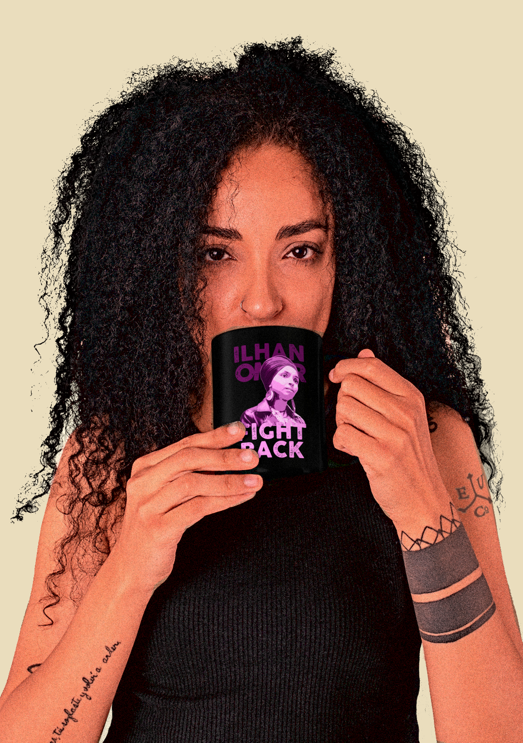 A woman with voluminous curly black hair holds a black mug in front of her mouth. The mug features a purple graphic of a woman's face and the text 'ILHAN OMAR FIGHT BACK' in purple and lavender.