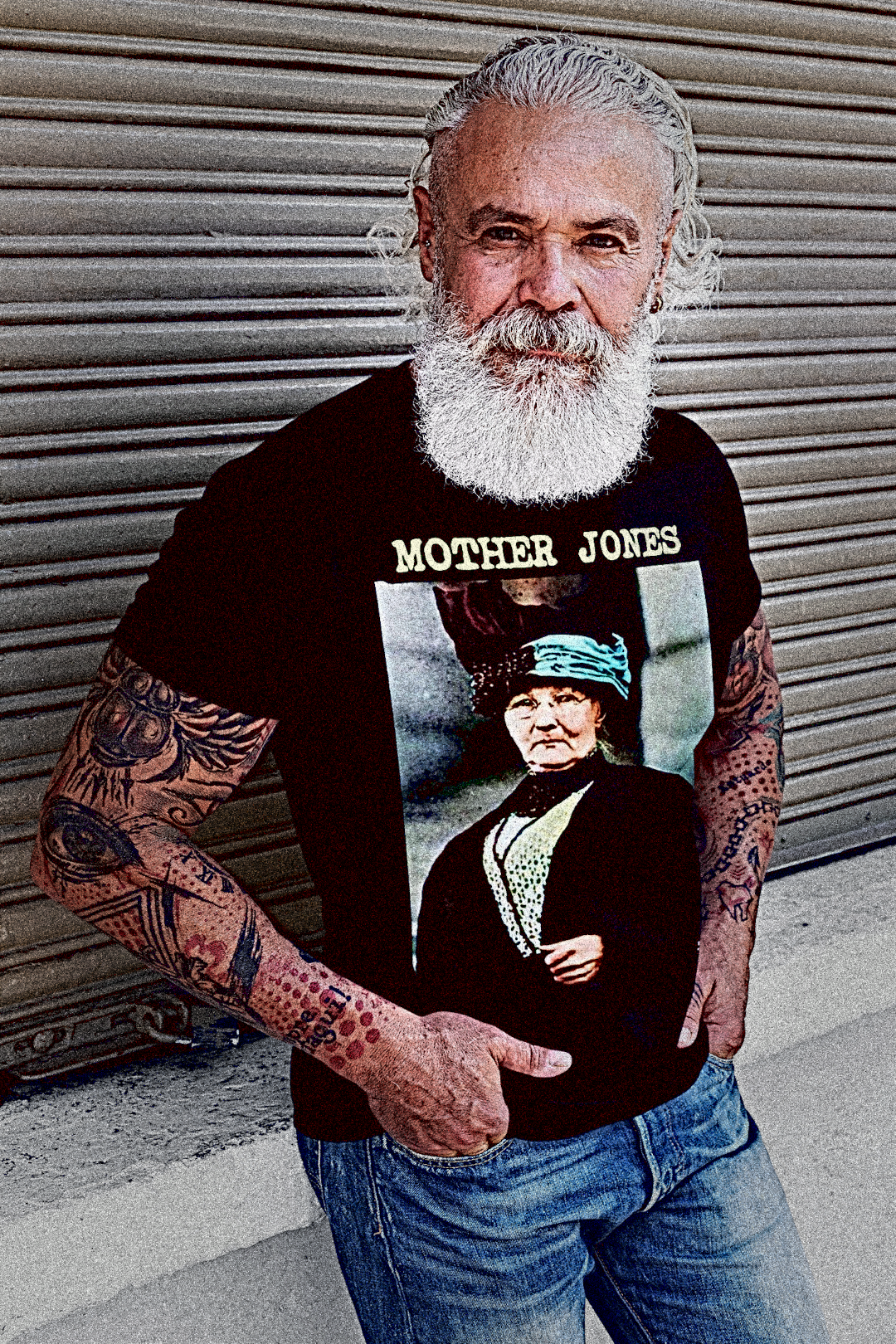 A burly older union organizer with muscular arms and tattoos, white hair and a lumberjack beard wearing a Basic Black T-Shirt: Mother Jones, fearless labor organizer who fought for miners, children, and the dignity of working people. Mary “Mother” Jones was called the most dangerous woman in America—and she wore the title proudly.
Perfect gift for the union organizer or anarcho-syndicalist in your life. Cotton Bella+Canvas 3001 #EUTC