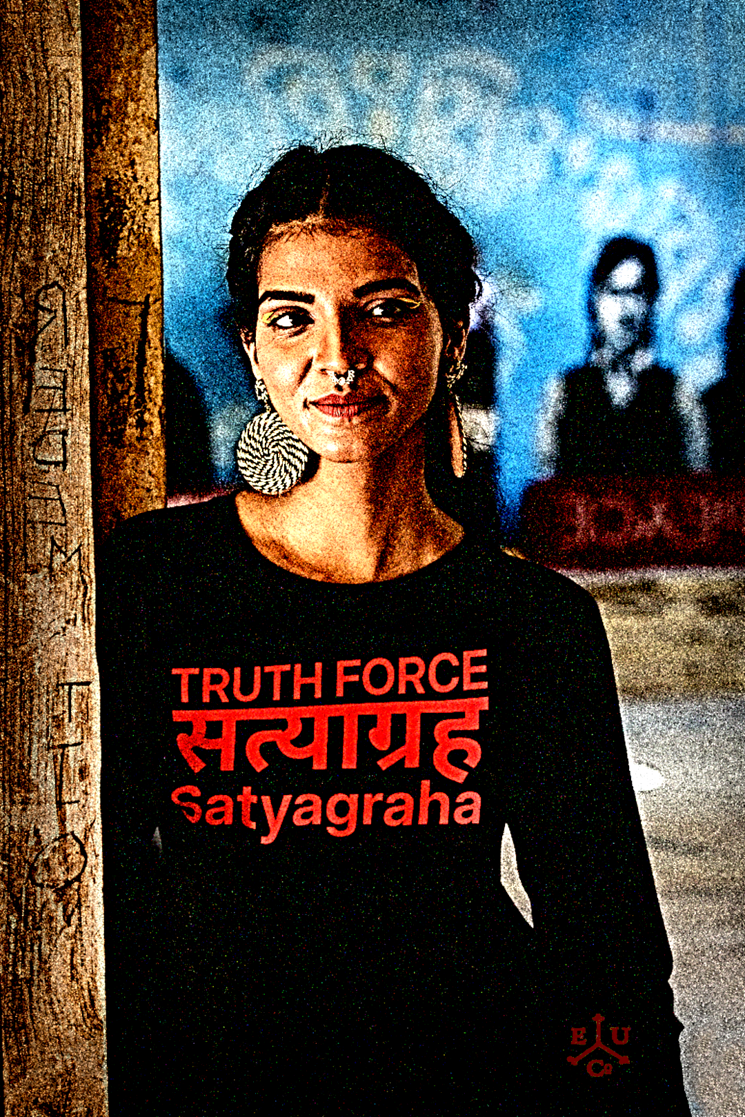 Slim India woman with large earings in front of graffiti mural wearing a Black Long Sleeve Jersey: Definition: SATYAGRAHA (noun) from the Sanskrit 1. Truth Force 2. A philosophy and practice of nonviolent resistance to injustice: holding firmly to truth. Holding firmly to truth, or truth force, is a particular form of nonviolent resistance. 

Perfect gift for the nonviolent protester in your life. Cotton Bella+Canvas 3501 #EUTC