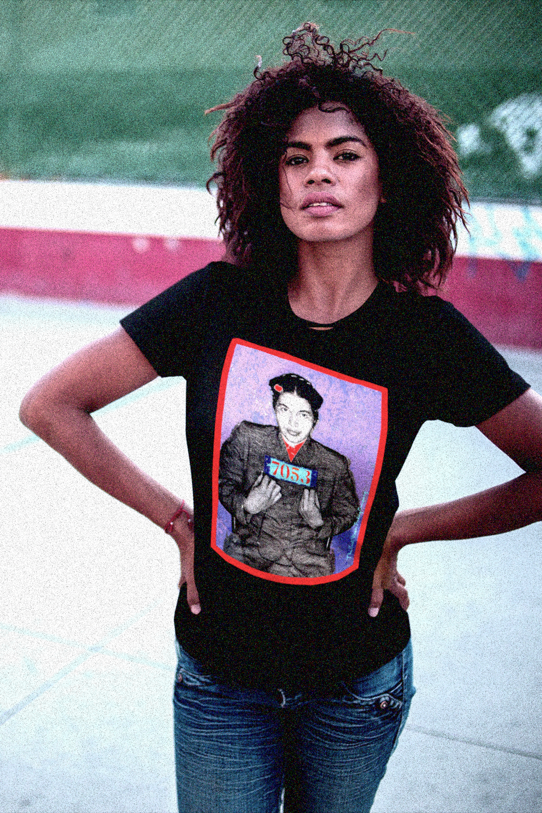 Defiant Black woman on basketball court wearing a relaxed fit women's tee depicting the mugshot of Rosa Parks, whose quiet defiance sparked the Montgomery Bus Boycott and galvanized the movement. Forget the myth of the tired seamstress—Rosa Parks was a trained activist who knew exactly what she was doing when she refused to give up her seat. Perfect gift for the feminist civil rights activist in your life.Bella+Canvas Women’s Relaxed Tee 6400  #EUTC 
