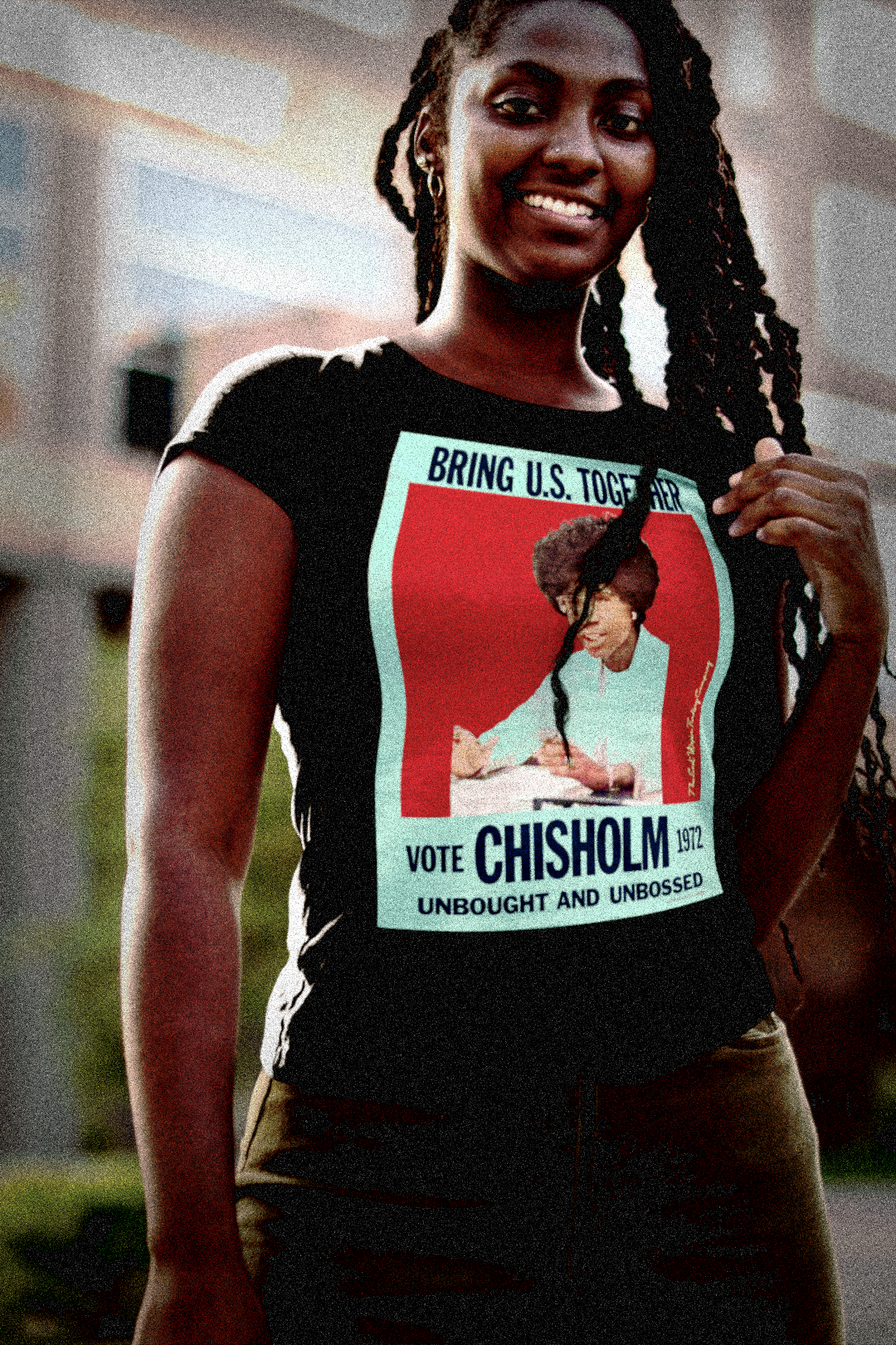Bold Black woman with long natty braids wearing a Black Relaxed Fit Womens T-Shirt:  Shirley Chisholm was “unbought and unbossed,” the first Black woman elected to Congress and the first to run for president in a major party. She smashed through the double barriers of race and gender, and she did it without asking permission. The perfect gift for the feminist budding political junkie in your life. Cotton Bella+Canvas 6400 #EUTC