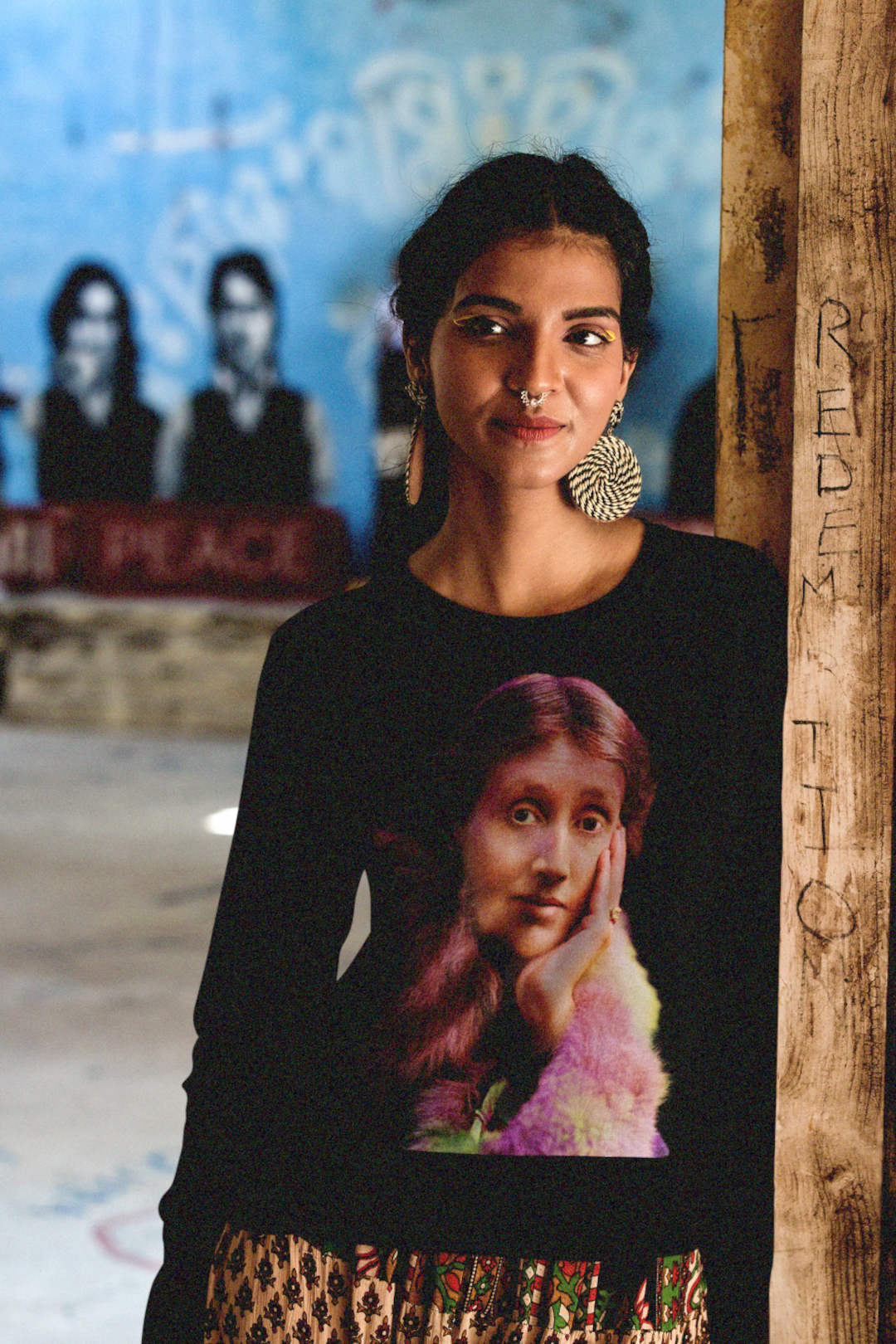 Slim Indian woman wearing a black long sleeve jersey with a technicolor photo of Virginia Woolf. 

Woolf made literature new—stream-of-consciousness, fractured time, inner lives spilling across the page. With novels like Mrs. Dalloway and To the Lighthouse, she redefined modernism not as escape but as immersion. 

Perfect gift for your book club friend or the English major in your life. Bella+Canvas Long Sleeve Jersey 3501 #EUTC
