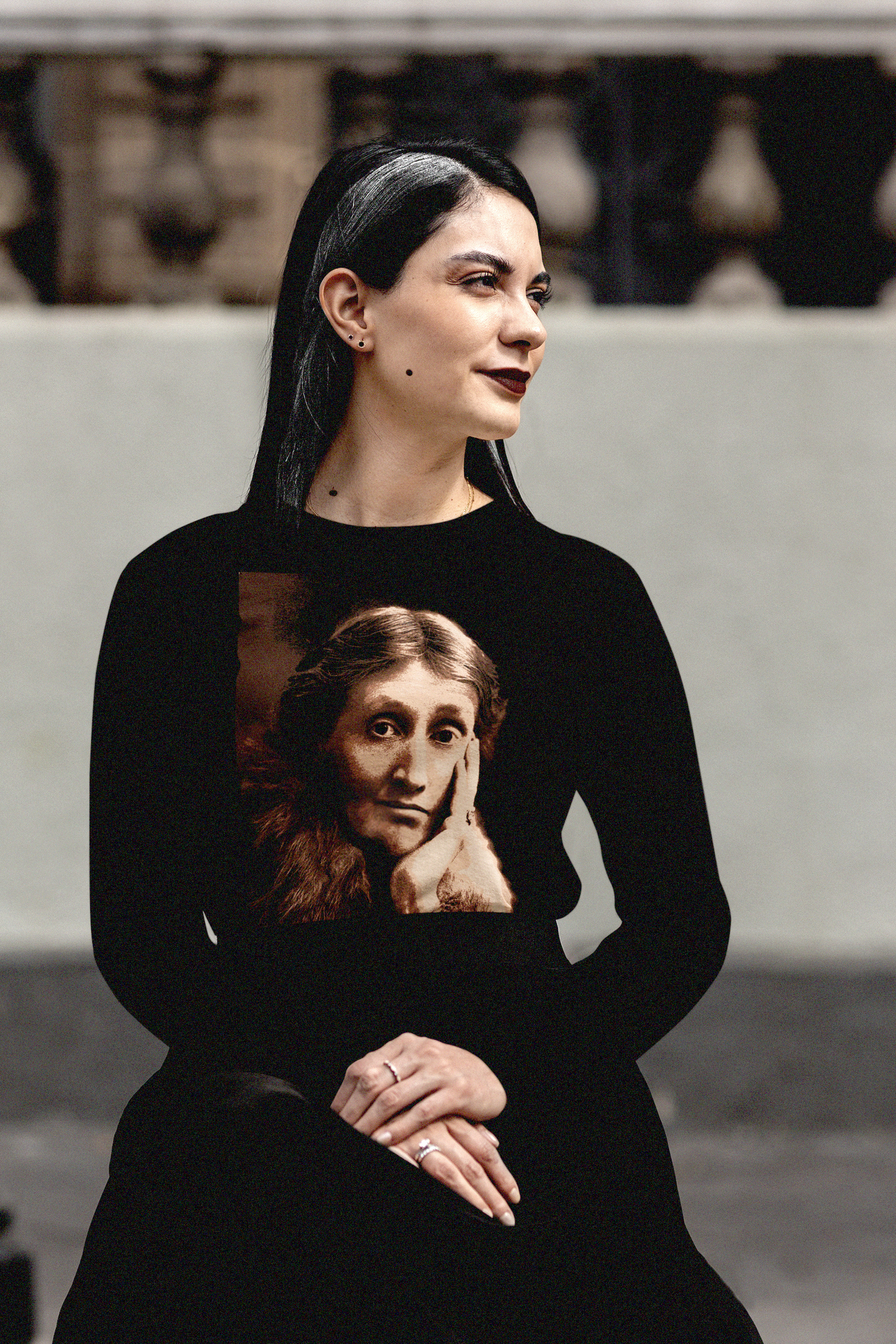 Seated gothesque grad student wearing Long sleeve black jersey with a sepia portrait of Virginia Woolf. She made literature new—stream-of-consciousness, fractured time, inner lives spilling across the page. With novels like Mrs. Dalloway and To the Lighthouse, she redefined modernism not as escape but as immersion. 

Photo shows fit and style. Perfect gift for your book club fit or the English major in your life. Bella+Canvas 3501 #EUTC