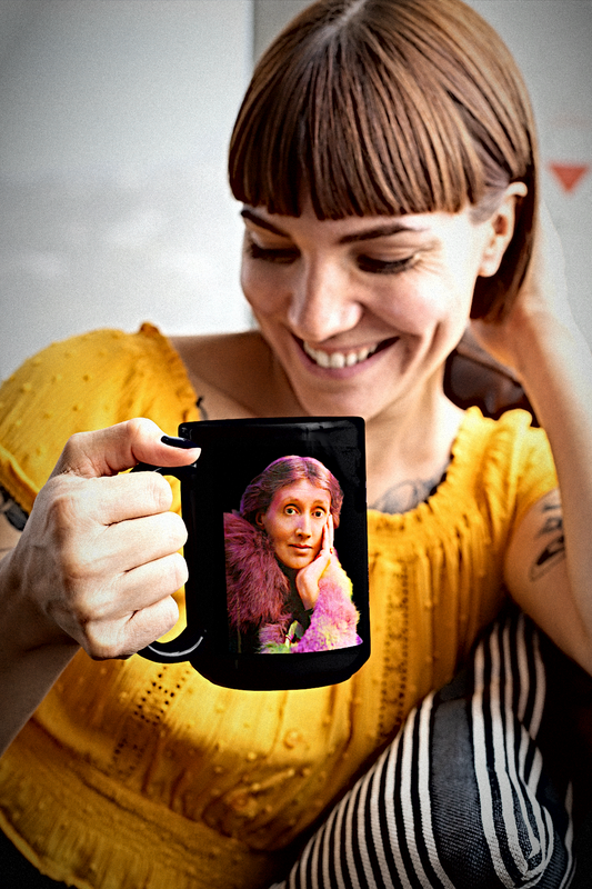 Woman with straight bangs in a breakfast nook holding a Virginia Woolf mug. 
